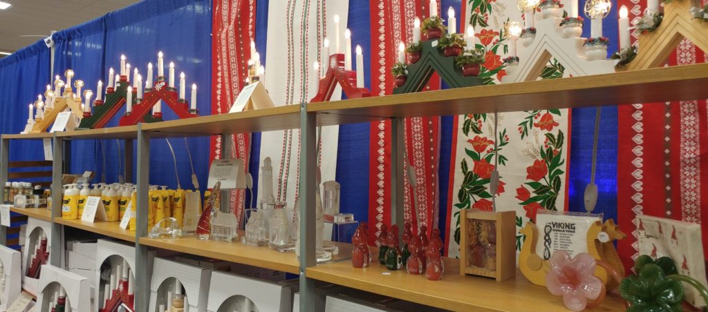 Retail show display booth with merchandise and Scandinavian textiles hanging behind it.